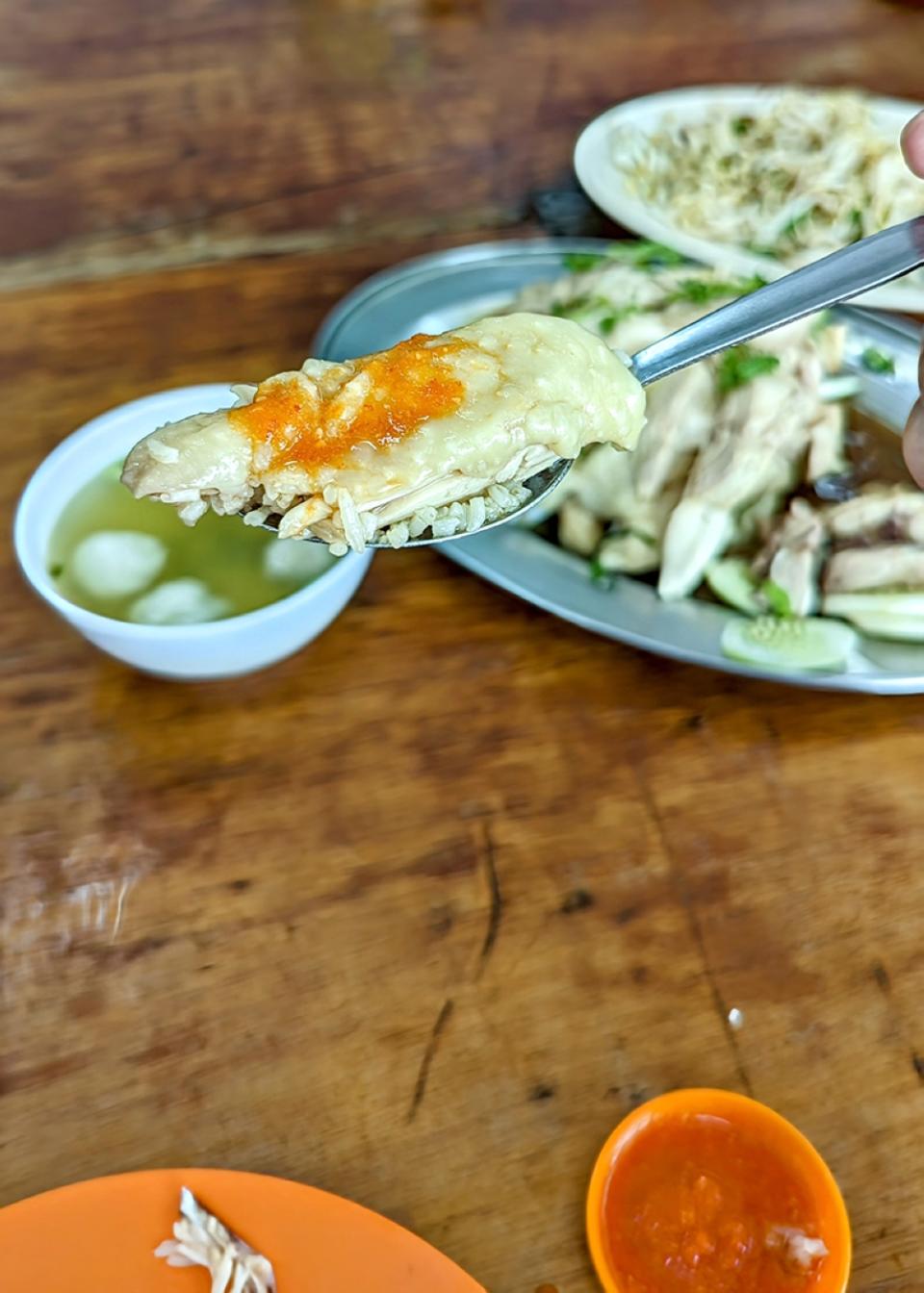 The perfect bite here: rice, a piece of chicken and a splotch of chilli sauce.