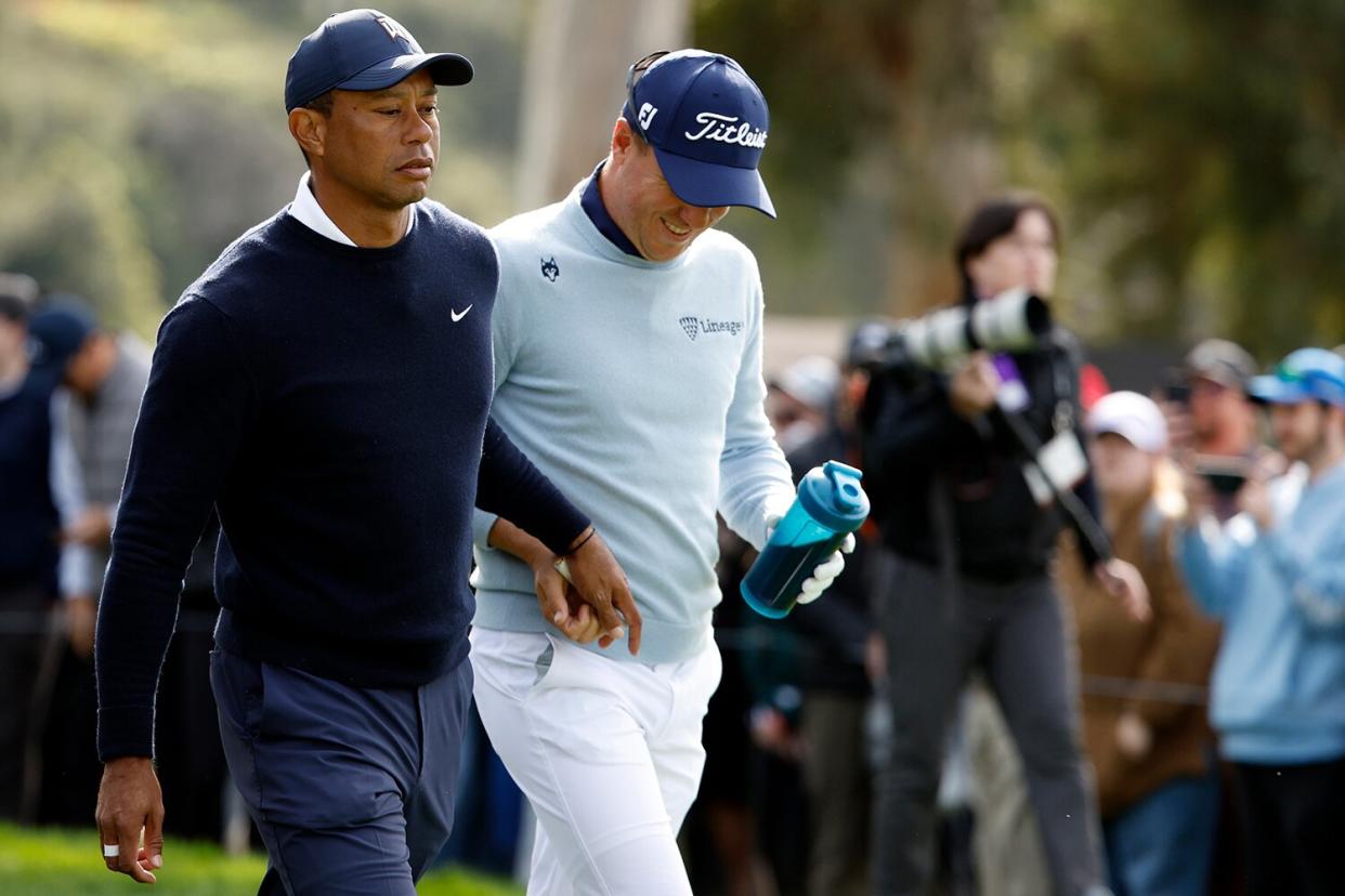 Tiger Woods of the United States (L) and Justin Thomas of the United States walk off the ninth tee during the first round of the The Genesis Invitational at Riviera Country Club on February 16, 2023 in Pacific Palisades, California.