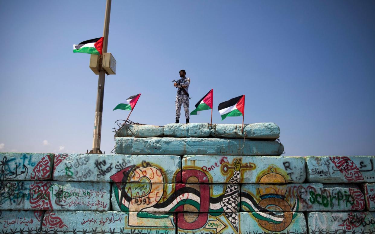 A Palestinian Hamas police officer stands guard at the Gaza seaport, in Gaza City - AP