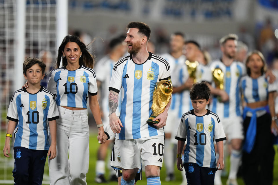 El astro argentino Lionel Messi, acompañado por su esposa Antonela Roccuzzo y sus hijos, carga la Copa Mundial durante un festejo en el amistoso contra Panamá, el jueves 23 de marzo de 2023, en el estadio Monumental de Buenos Aires. (AP Foto/Natacha Pisarenko)