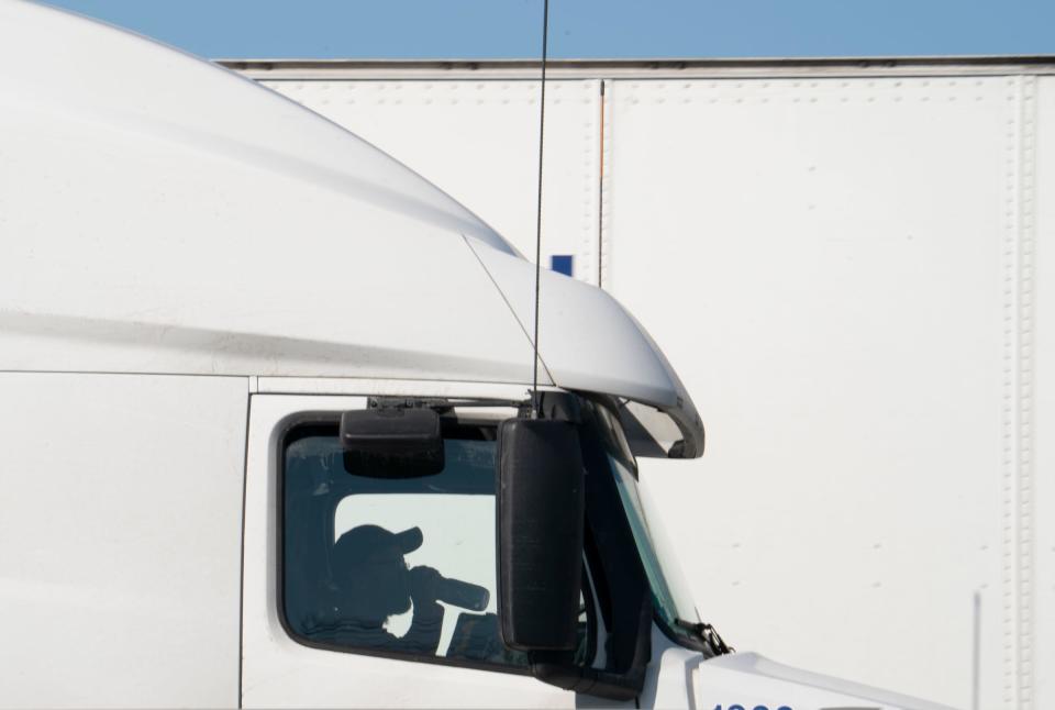 A trucker can be seen taking a swig as he waits to cross the Blue Water Bridge. After the Ambassador Bridge was closed due to Canadian anti-vaccine protests, traffic was diverted to the Blue Water Bridge in Port Huron causing miles-long backups on Feb. 9, 2022. From an overpass, the Interstate 94 approach to the Blue Water Bridge heading to Canada was packed with transfer trucks.