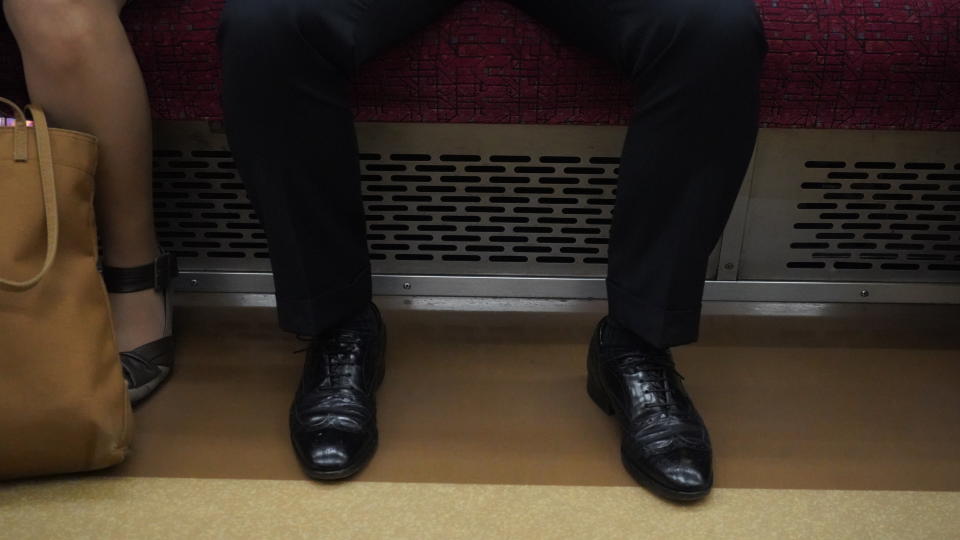 a man manspreading on the subway