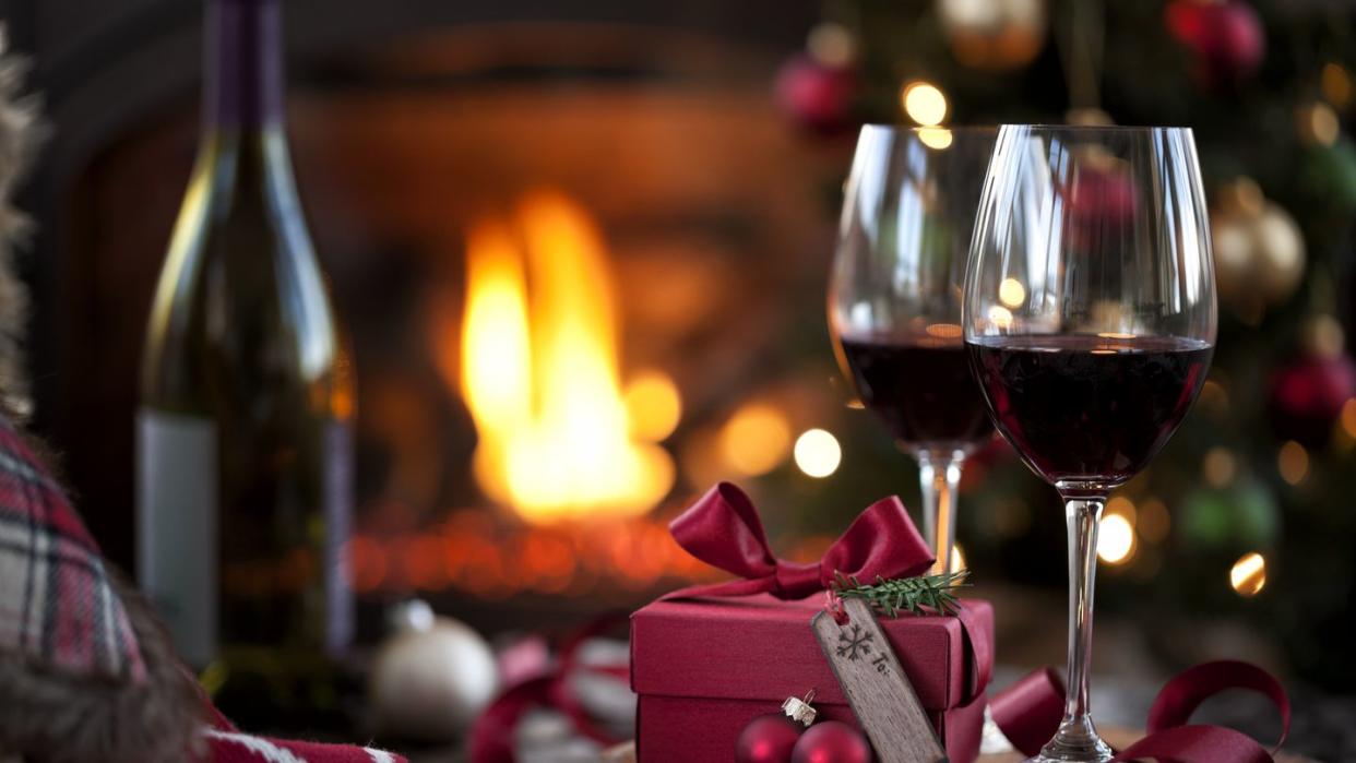 christmas red wine and a gift in front of a fireplace very shallow depth