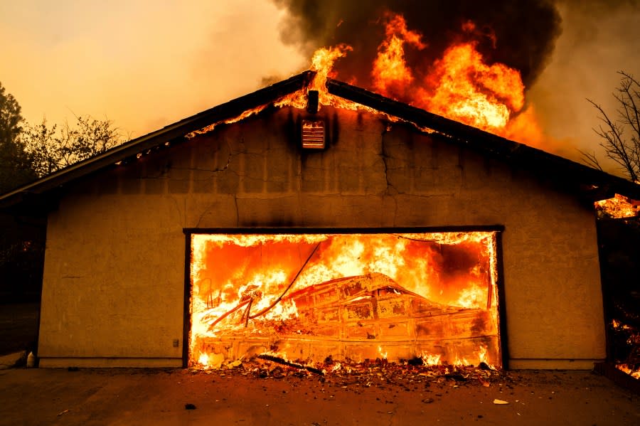 Flames consume a garage as the Thompson Fire burns in Oroville, Calif., Tuesday, July 2, 2024. (AP Photo/Noah Berger)