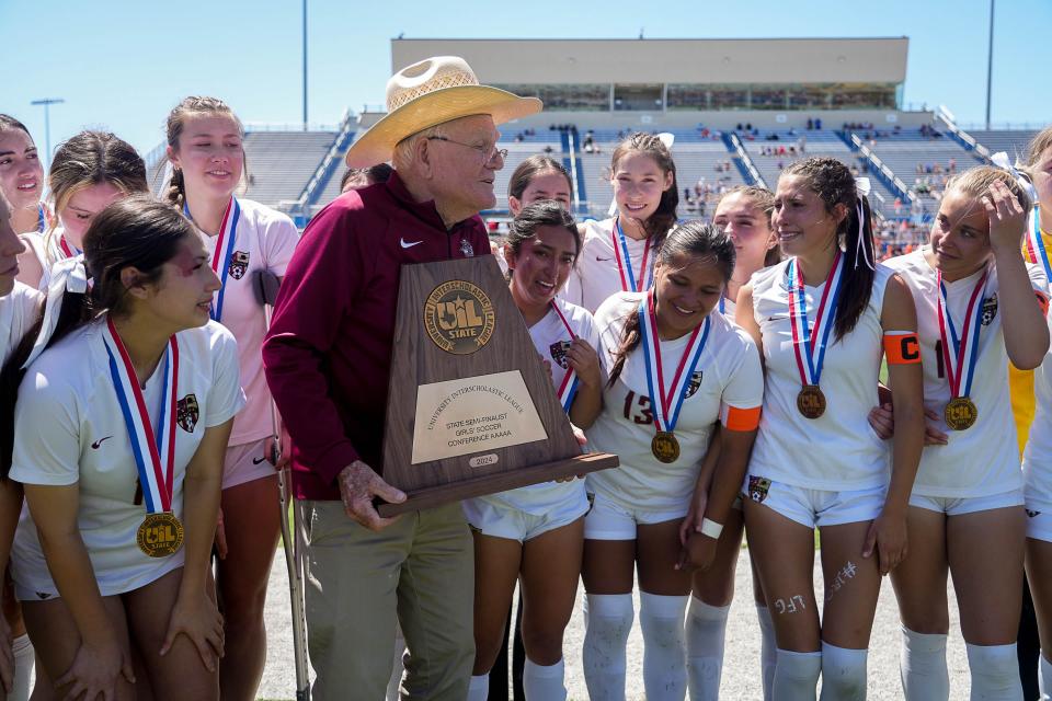 Charles E. Rouse, the namesake of Rouse High School, presents the runner-up trophy to the team after the loss to Frisco Wakeland.