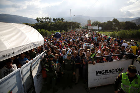 Colombian police officers stand in front of people queueing to try to cross into Colombia from Venezuela through Simon Bolivar international bridge in Cucuta, Colombia January 24, 2018. REUTERS/Carlos Garcia Rawlins