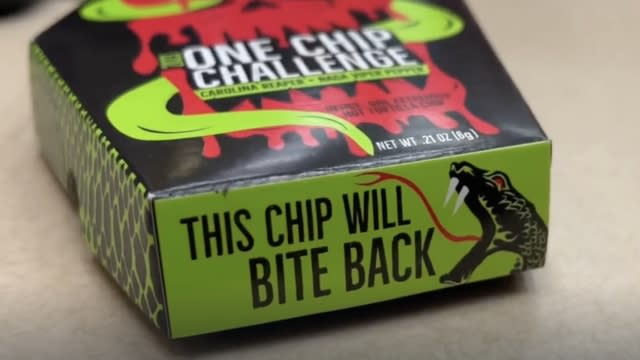 Paqui tortilla box behind the One Chip Challenge reads "THIS CHIP WILL BITE BACK."