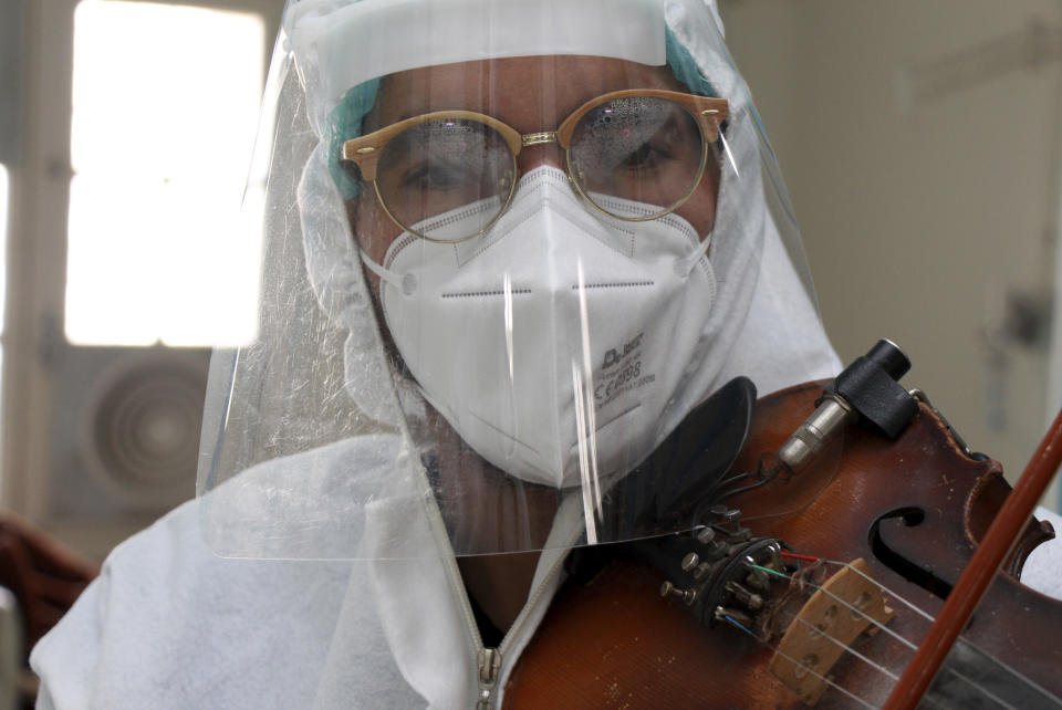 Dr. Mohamed Salah Siala plays the violin for patients on the COVID wards of the Hedi Chaker hospital in Sfax, eastern Tunisia, Saturday Feb. 20, 2021. When the 25-year-old decided to get out his violin one day at Hedi Chaker Hospital in city of Sfax and play, it won praise for boosting the morale of virus sufferers who remained isolated and needed a smile. (AP Photo)