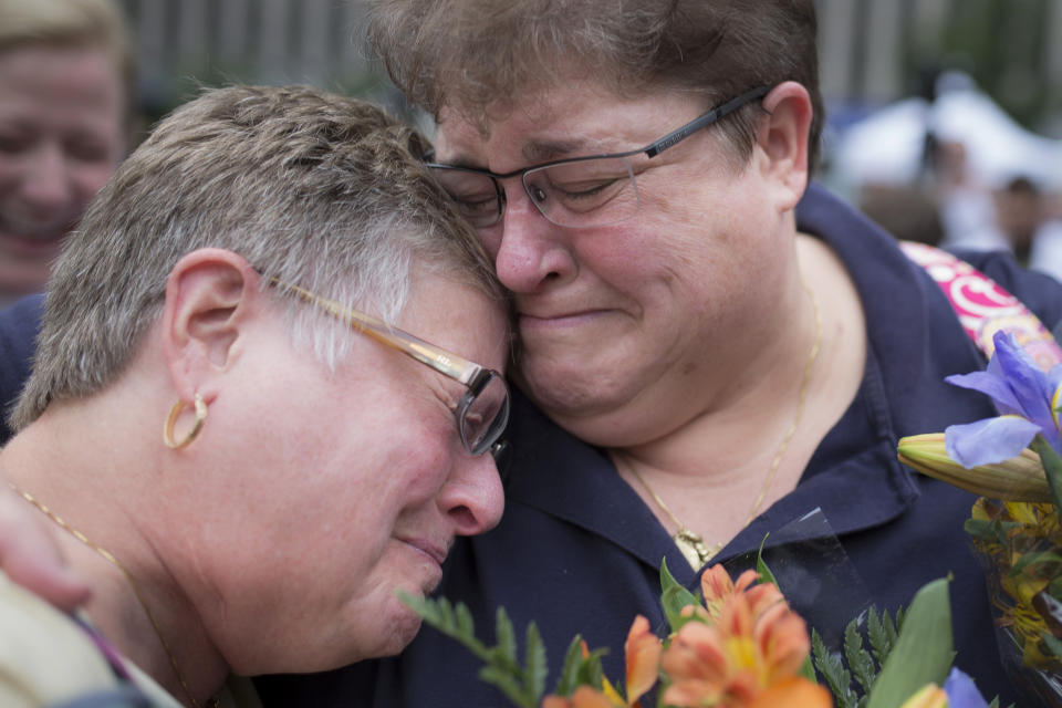 FILE - Barb Eisenhart, left, and Tiffany Wahl, embrace before their marriage ceremony at Fountain Square on June 26, 2015, in Cincinnati, after the Supreme Court declared that same-sex couples have a right to marry anywhere in the United States. Ohio was one of 14 states enforcing a ban on same-sex marriage. (AP Photo/John Minchillo, File)