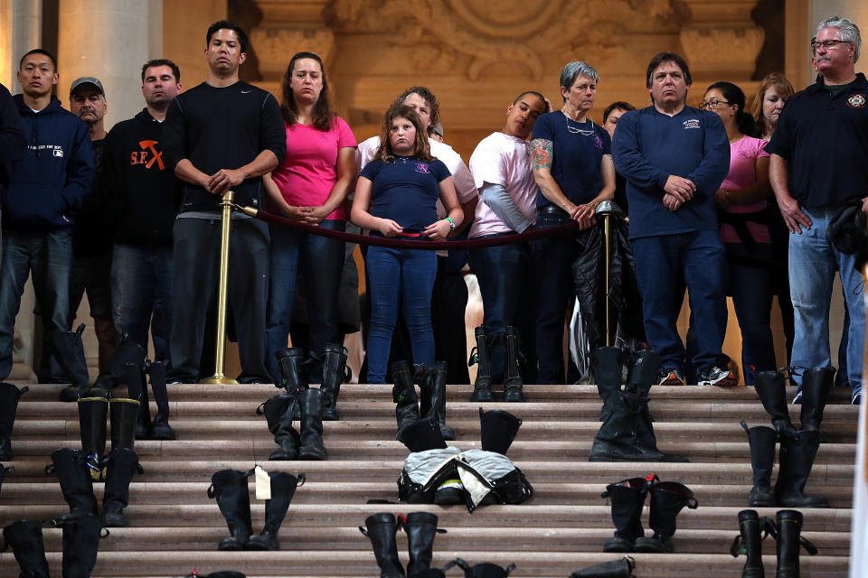 SAN FRANCISCO, CA - MARCH 26:  Firefighters and their families look over a display of firefighter boots during a remembrance ceremony held for San Francisco firefighters who have died of cancer on March 26, 2014 at San Francisco City Hall in San Francisco, California. Over two hundred pairs of boots were displayed on the steps inside San Francisco City Hall to symbolize the 230 San Francisco firefighters who have died of cancer over the past decade. According to a study published by the National Institute for Occupational Safety and Health, (NIOSH)  findings indicate a direct correlation between exposure to carcinogens like flame retardants and higher rate of cancer among firefighters.  The study showed elevated rates of respiratory, digestive and urinary systems cancer and also revealed that participants in the study had high risk of mesothelioma, a cancer associated with asbestos exposure.  (Photo by Justin Sullivan/Getty Images)