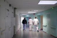 Medical staff of the emergency ward of the Rouvray psychiatric hospital accompany a patient to his room, in Rouen, western France, Wednesday, Nov. 25, 2020. Lockdowns that France has used to fight the coronavirus have come at considerable cost to mental health. Surveying points to a surge of depression most acute among people without work, in financial hardship and young adults. (AP Photo/Thibault Camus)