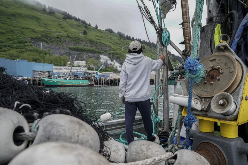 Juan Zuniga, a first-year deckhand on the Agnes Sabine, looks out as the boat returns to the harbor after refueling, Friday, June 23, 2023, in Kodiak, Alaska. For some young people who make the move to Alaska's coasts, the industry is a way to make quick money, but not a forever job. “This is a pretty far place from where I live,” Zuniga said. “It’s a very big step out of my comfort zone." (AP Photo/Joshua A. Bickel)