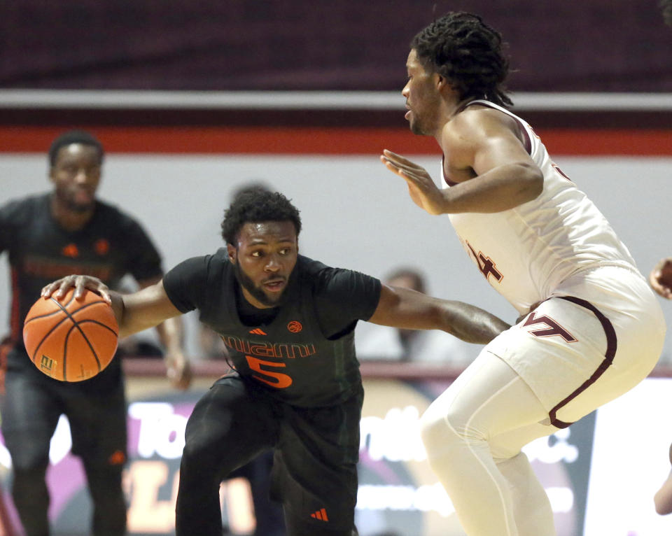 Miami's Wooga Poplar (5) is defended by Virginia Tech's Mylyjael Poteat (34) during the first half of an NCAA college basketball game Saturday, Jan. 13, 2024, in Blacksburg, Va. (Matt Gentry/The Roanoke Times via AP)