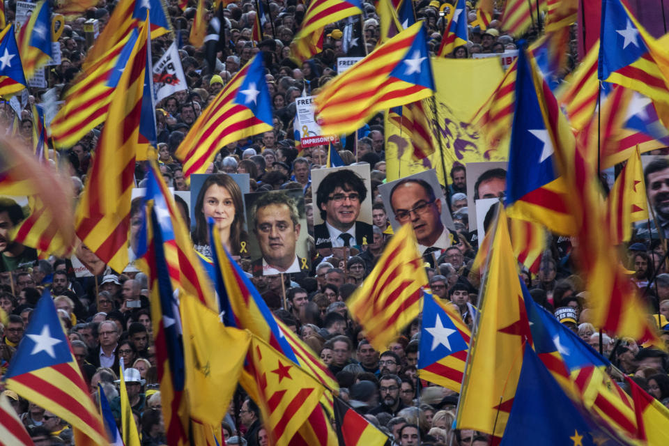 Pro independence demonstrators hold photos of imprisoned pro independence political leaders, during a demonstration in Barcelona, Spain, Saturday, Feb. 16, 2019. Some thousands of Catalan separatists are marching in Barcelona to proclaim the innocence of 12 of their leaders who are on trial for their role in a failed 2017 secession bid. (AP Photo/Emilio Morenatti)