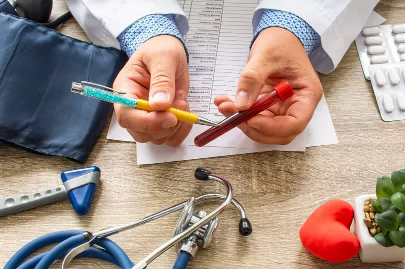 Doctor during consultation held in his hand and shows patient laboratory tube with blood. Counseling of transfusion, blood and hematologic diseases and pathology like anemias, cell cancer, hemophilia