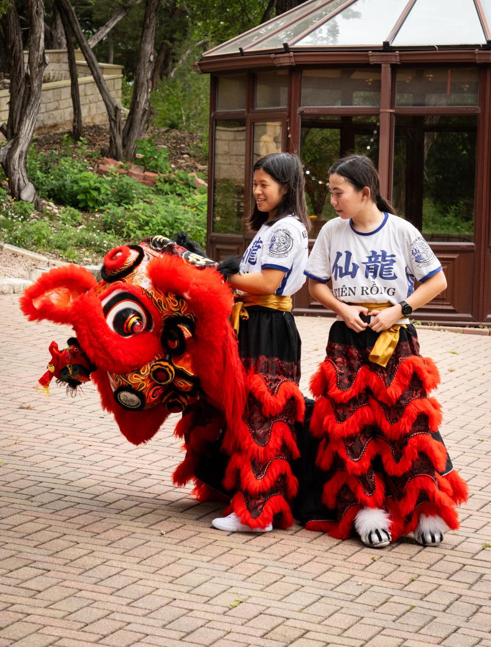Jordyn Chang, left, and Maya Goodman take a break while practicing lion dancing with Heavenly Dragon Lion Dance Association at the Fo Guang Shan Xiang Yun Temple in Austin, May 11, 2024.