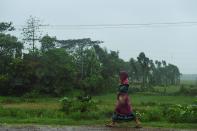 A woman walks along a road under the rain ahead of the expected landfall of cyclone Amphan in Midnapore, West Bengal, on May 20, 2020. (Photo by DIBYANGSHU SARKAR/AFP via Getty Images)