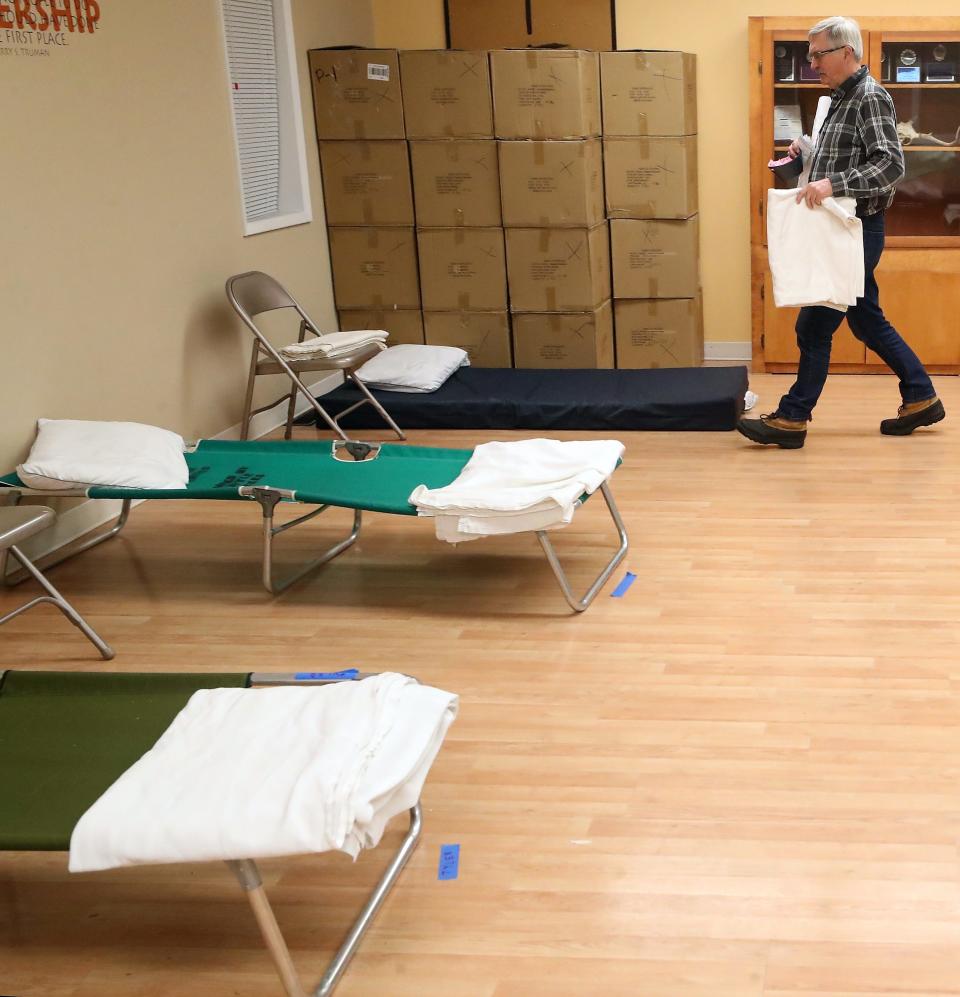 Roland Arper, site manager of the severe weather shelter at Port Orchard United Methodist Church, carries a second blanket to a cot prior to the shelter opening on Wednesday.