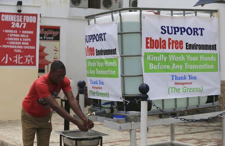 A man washes his hands at a tap outside the Green Pharmacy at Area 8 in Abuja, September 1, 2014. REUTERS/Afolabi Sotunde