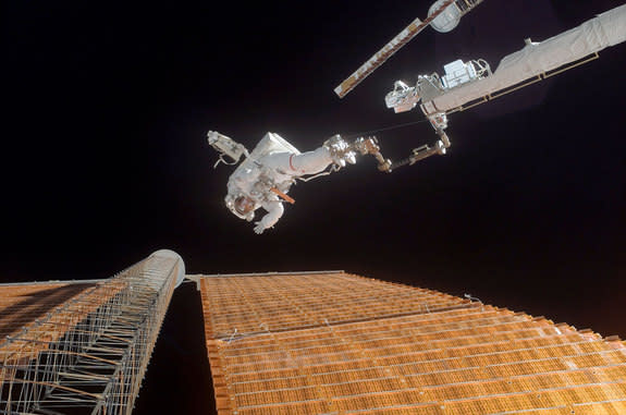 Astronaut Scott Parazynski, STS-120 mission specialist, assesses his repair work as the International Space Station’s solar array is fully deployed in 2007.