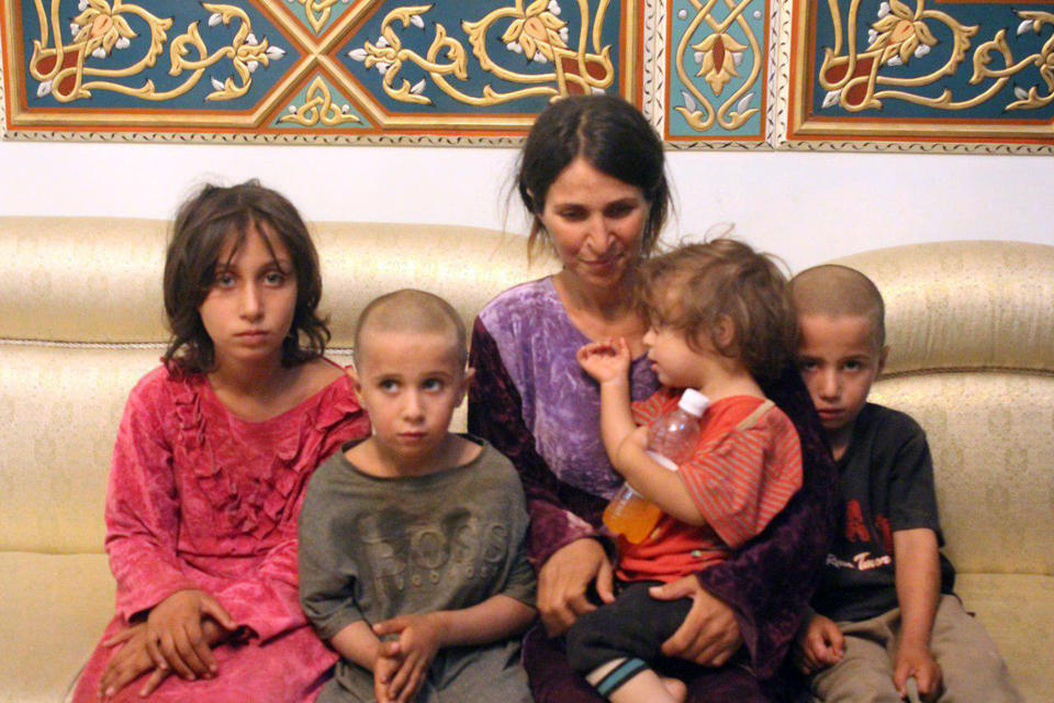 This photo released by the Syrian official news agency SANA shows Abeer Shalgheen and her four children after being freed by the Islamic State group that kidnapped them on July 25 during a raid by the extremists on the southern province of Sweida, Syria, Saturday, Oct. 20, 2018. The Islamic State group early Saturday released two women and four children they had been holding since July in the first part of an exchange with the Syrian government that will set free dozens of women related to members of the extremist group, opposition activists said. (SANA via AP)