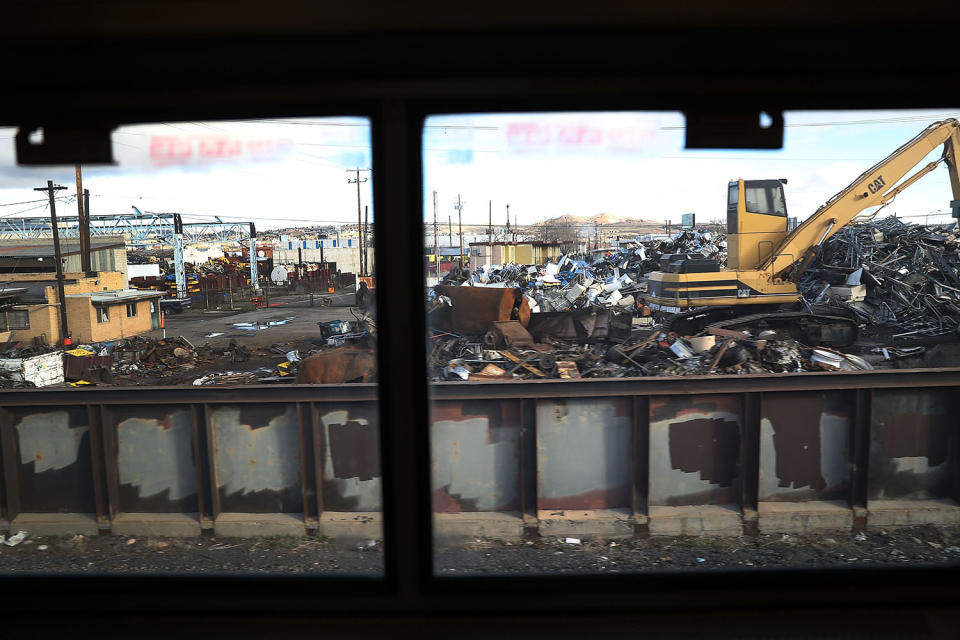 Amtrak train rolling past salvage yard