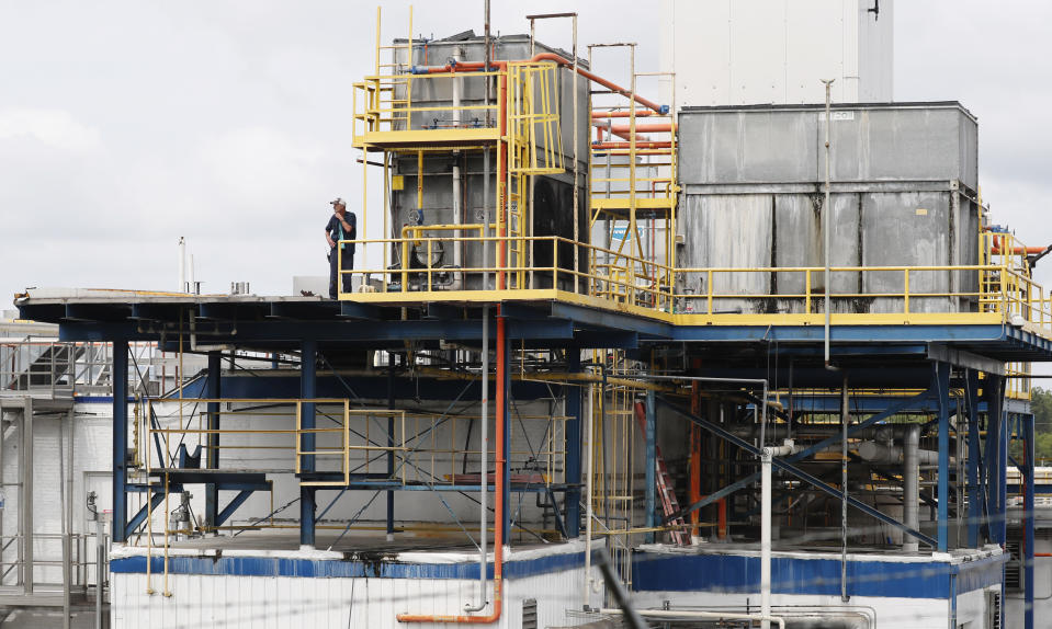 A plant employee stands near a refrigeration unit as business continues at this Koch Foods Inc., plant in Morton, Miss., Thursday, Aug. 8, 2019, following Wednesday's raid by U.S. immigration officials. In an email Thursday, U.S. Immigration and Customs Enforcement spokesman Bryan Cox said more than 300 of the 680 people arrested Wednesday have been released from custody. (AP Photo/Rogelio V. Solis)