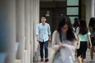 Nathan Law (L), Hong Kong's youngest ever lawmaker, walks past fellow students at Lingnan University