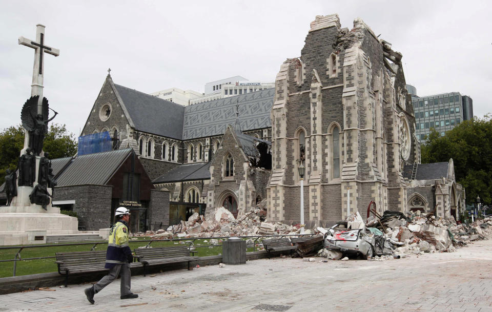 FILE - In this Feb. 26, 2011, file photo, a relief worker walks past the earthquake-damaged Christchurch Cathedral in Christchurch, New Zealand. The virus outbreak is compromising the ability of nations to prepare for natural disasters and deal with the aftermath. Every year, the world contends with devastating typhoons, wildfires, tsunamis and earthquakes. (AP Photo/Mark Baker,File)