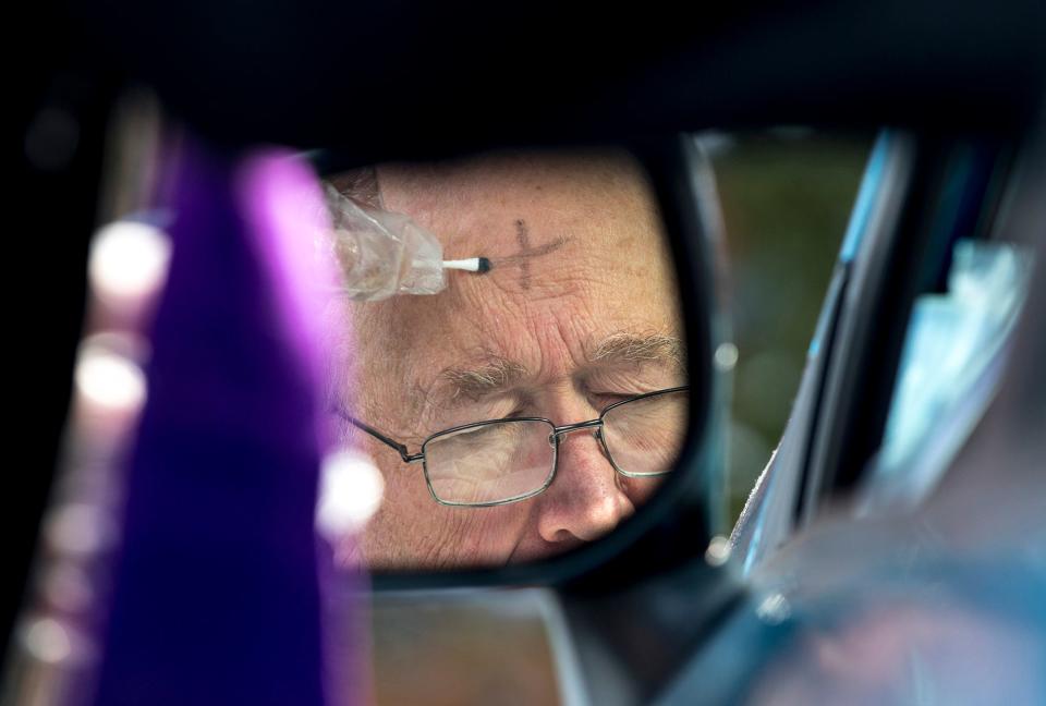 A parishioner receives ashes during a drive-thru service in Finneytown, Ohio, in February 2021.