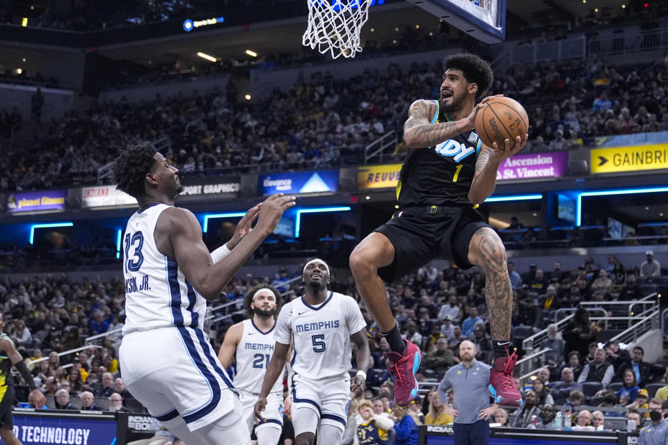 Indiana Pacers forward Obi Toppin (1) makes a pass over Memphis Grizzlies forward Jaren Jackson Jr. (13) during the first half of an NBA basketball game in Indianapolis, Sunday, Jan. 28, 2024. (AP Photo/Michael Conroy)