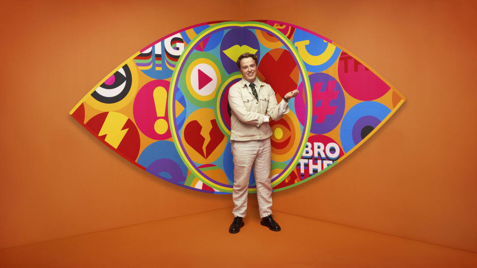 Henry in front of the Big Brother logo.