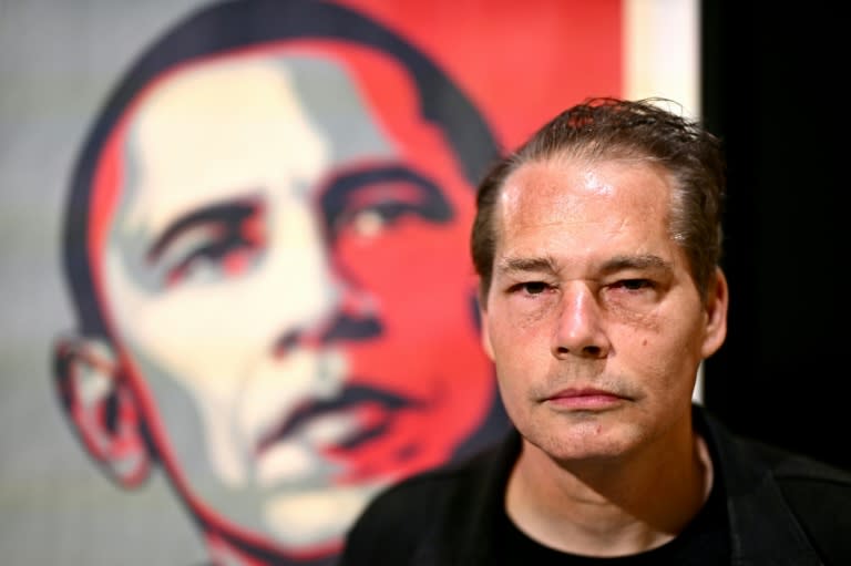 L'artiste américain Shepard Fairey, alias Obey, devant une affiche de Barak Obama, lors de l'avant-première de l'exposition "Obey: The art of Shepard Fairey" à la Fabbrica del Vapore, le 15 mai 2024 à Milan (GABRIEL BOUYS)