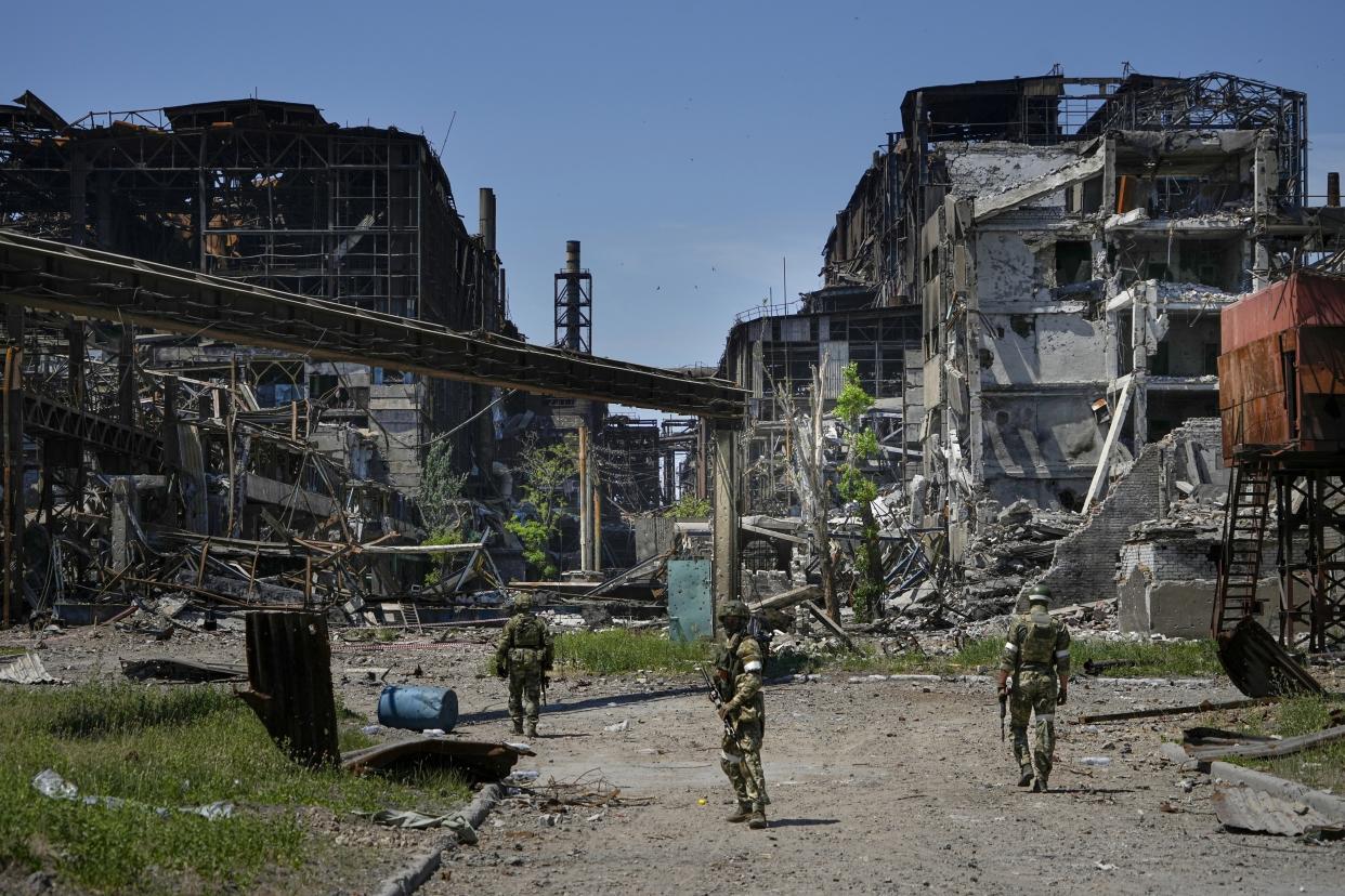 FILE - Russian soldiers patrol an area of the Metallurgical Combine Azovstal, in Mariupol, on the territory which is under the Government of the Donetsk People's Republic control, eastern Ukraine, on June 13, 2022. According to Russian state TV, the future of the Ukrainian regions occupied by Moscow's forces is all but decided: Referendums on becoming part of Russia will soon take place there, and the joyful residents who were abandoned by Kyiv will be able to prosper in peace. In reality, the Kremlin appears to be in no rush to seal the deal on Ukraine's southern regions of Kherson and Zaporizhzhia and the eastern provinces of Donetsk and Luhansk. (AP Photo, File)