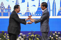 Cambodian Prime Minister Hun Sen, left, hands over the gavel to Indonesian President Joko Widodo during a transfer of ASEAN Chairmanship at the closing ceremonies of the 40th and 41st ASEAN Summit and Related Summits in Phnom Penh, Cambodia, Sunday, Nov. 13, 2022. (AP Photo/Anupam Nath)