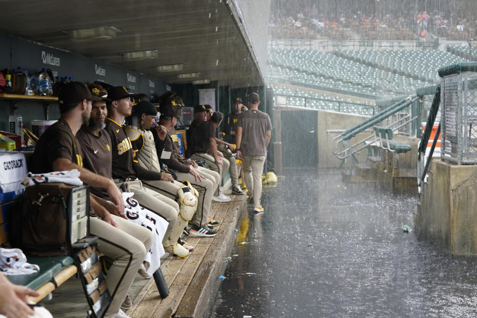 San Diego Padres players sit in the dugout during a rain delay in the second inning of a baseball game against the Detroit Tigers, Saturday, July 22, 2023, in Detroit. (AP Photo/Paul Sancya)
