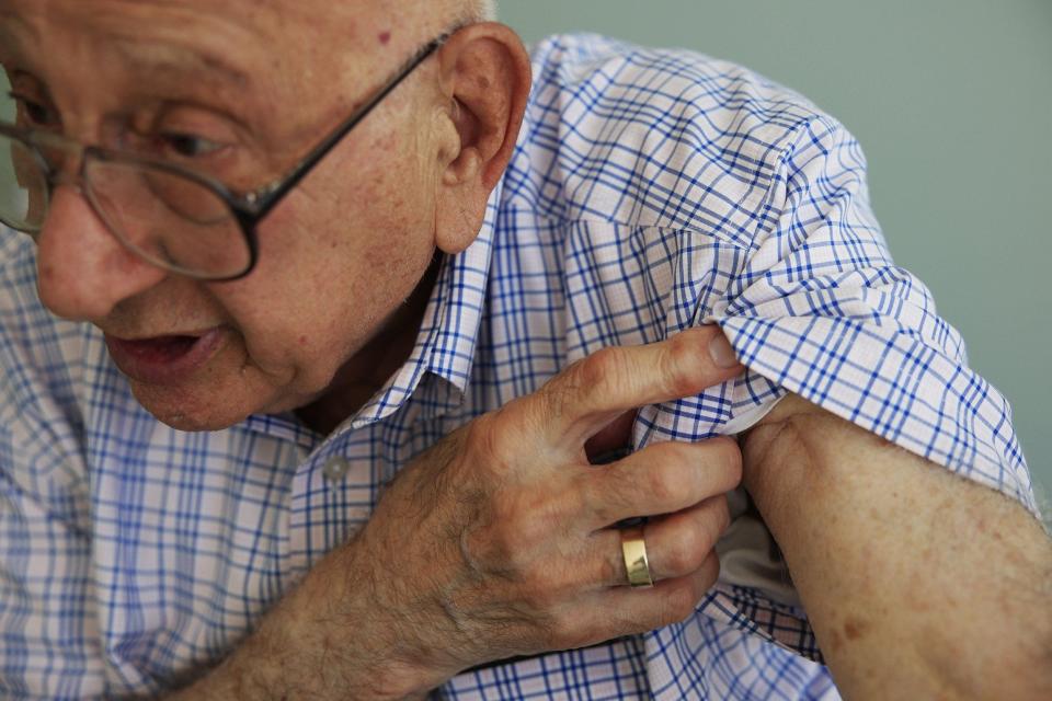 Sam Newey, 98, shows one of his wounds from a mortar explosion in 1945 in Eastern France.