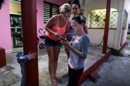 Dayali Lopez (R) connects her mobile device to the internet in Varadero, Cuba, December 6, 2018. Picture taken December 6, 2018. REUTERS/Fernando Medina