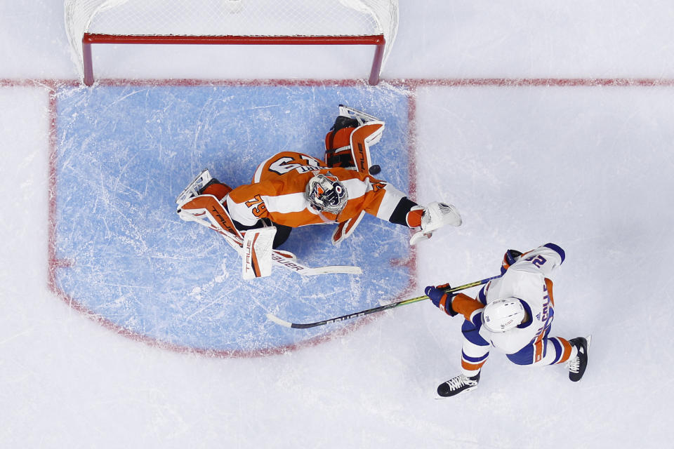 New York Islanders' Michael Dal Colle, right, tries to deflect a shot past Philadelphia Flyers' Carter Hart during the first period of a preseason NHL hockey game, Tuesday, Sept. 28, 2021, in Philadelphia. (AP Photo/Matt Slocum)
