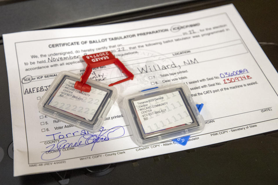 Data flash cards sit on certification forms for ballot-counting machines bearing the signature of Torrance County Clerk Yvonne Otero as testing begins at a county warehouse in Estancia, N.M., on Sept. 29, 2022.  (Andres Leighton / AP file)