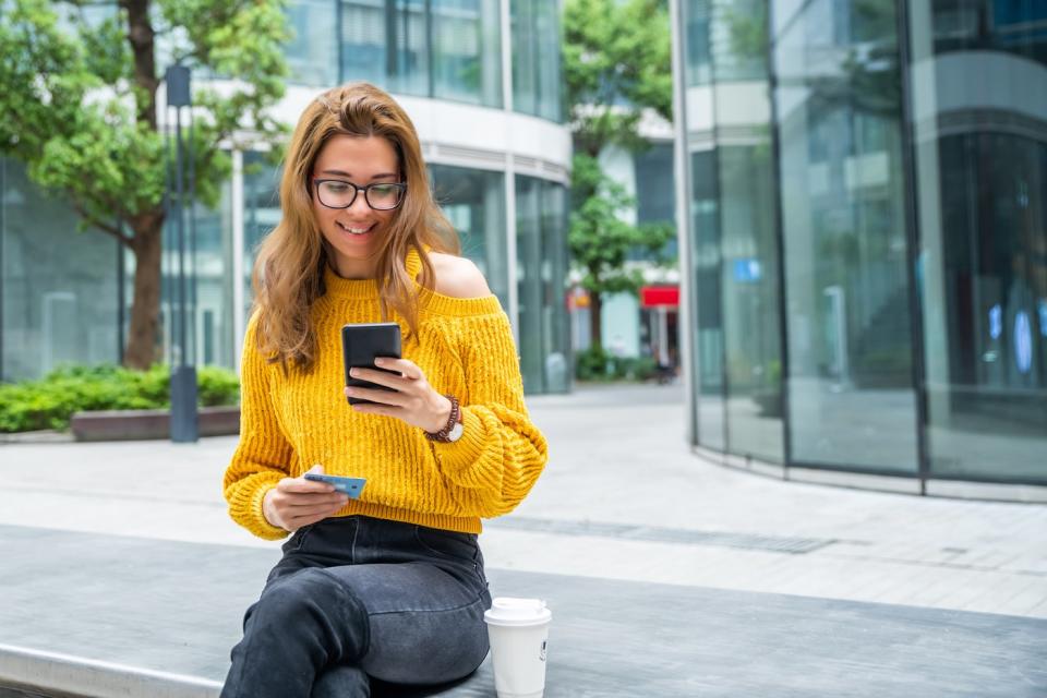 Woman sitting and looking at phone. 