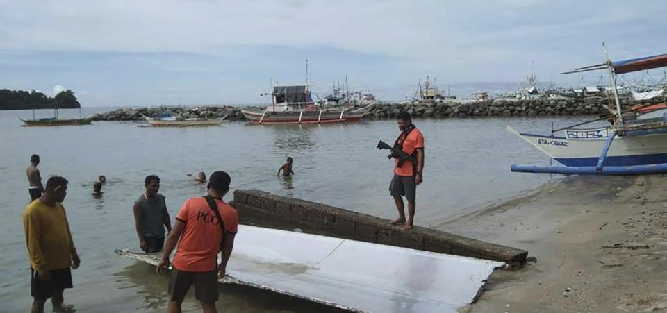 In this handout photo provided by the Philippine Coast Guard, Coast Guard personnel inspect debris, which the Philippine Space Agency said has markings of the Long March 5B (CZ-5B) Chinese rocket that was launched on July 24, after it was found in waters off Mamburao, Occidental Mindoro province, Philippines on Aug. 2, 2022. In July, the core stage debris of the Long March 5B rocket that was launched in China landed in Philippine waters in an uncontrolled reentry, the agency said. No damage or injuries were reported. (Philippine Coast Guard via AP)