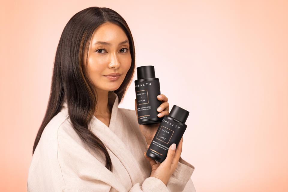 woman holding SJHealth vitamin powered shampoo and conditioner