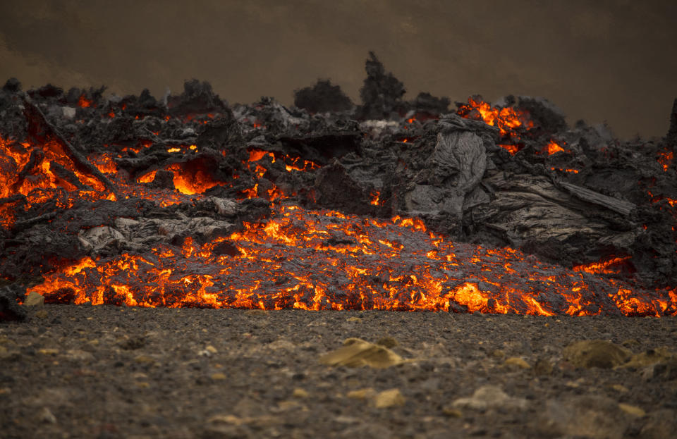 Lava flows from a new fissure on a volcano on the Reykjanes Peninsula in southwestern Iceland, Monday, April 5, 2021. The new fissure has opened up at the Icelandic volcano that began erupting last month, prompting the evacuation of hundreds of hikers who had come to see the spectacle. Officials say the new fissure is about 500 meters (550 yards) long and about one kilometer (around a half-mile) from the original eruption site in the Geldinga Valley (AP Photo/Marco Di Marco)