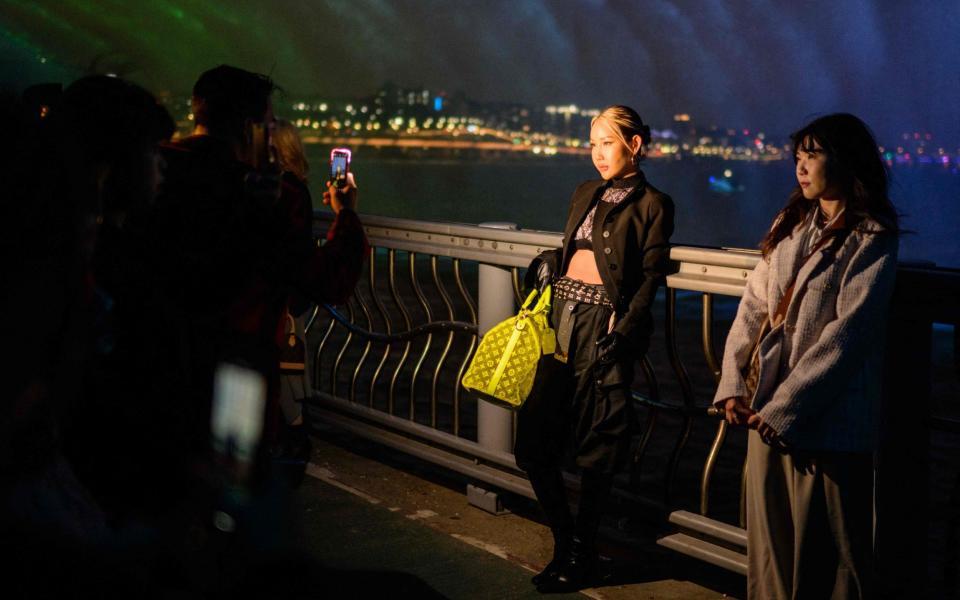 Guests pose on the bridge ahead of Louis Vuitton's Pre-fall show - AFP