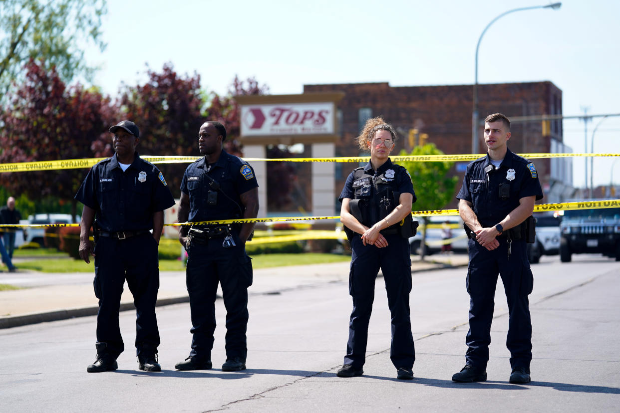 Police stand watch outside the scene of a shooting at a supermarket in Buffalo, N.Y., Sunday, May 15, 2022. A white 18-year-old wearing military gear and livestreaming with a helmet camera opened fire with a rifle at a supermarket in Buffalo, killing and wounding people in what authorities described as “racially motivated violent extremism.” (AP Photo/Matt Rourke)