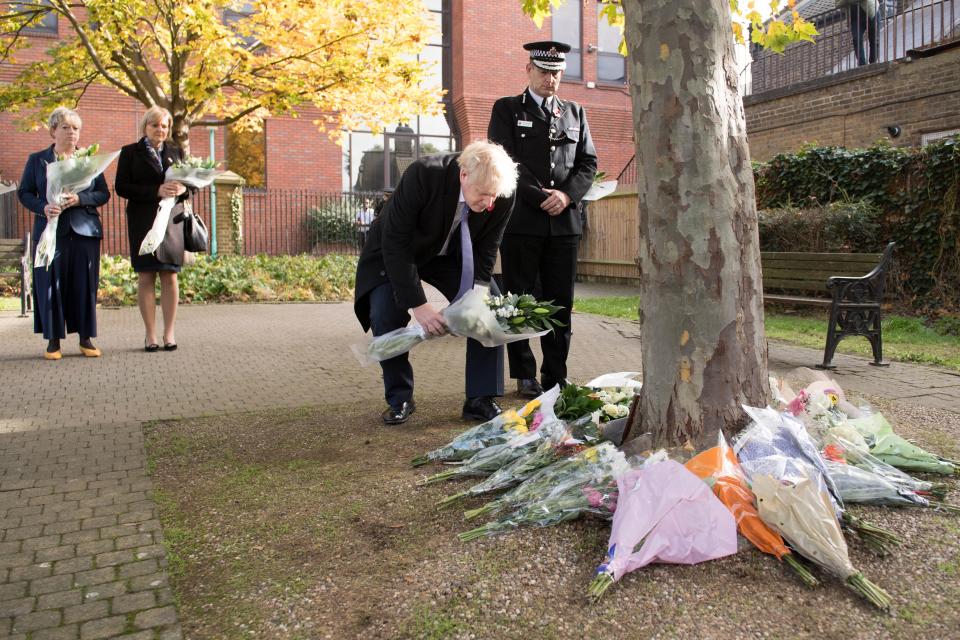 Britain's Prime Minister Boris Johnson stands with Chief Constable of Essex Police, Ben-Julian Harrington (R), as he lays flowers, during a visit to Thurrock Council Offices in Thurrock, east of London on October 28, 2019, following the October 23, 2019, discovery of 39 bodies concealed in a lorry. - British police investigating the deaths of 39 people in a refrigerated truck charged the driver on Saturday with manslaughter and people trafficking, as families in Vietnam expressed fear their loved ones were among the dead. (Photo by Stefan Rousseau / POOL / AFP) (Photo by STEFAN ROUSSEAU/POOL/AFP via Getty Images)