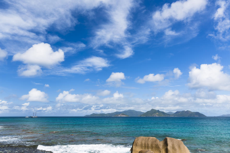 View at the wild north coast of La Digue, Seychelles with the island of Praslin in the background