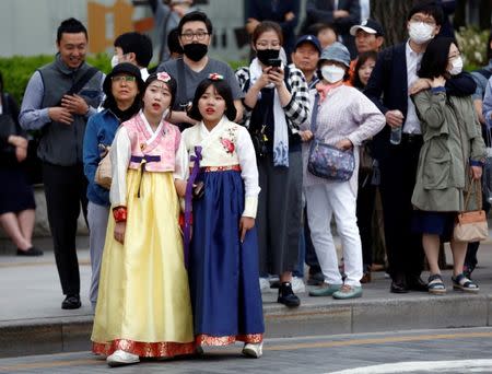 Pedestrians watch an election campaign rally of Moon Jae-in, the presidential candidate of the Democratic Party of Korea, in Seoul, South Korea May 8, 2017. REUTERS/Kim Kyung-Hoon