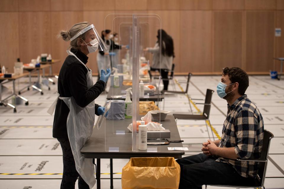 A member of staff instruct a student on how to self-administer a swab for a lateral flow Covid-19 test at the University of Hull (AFP via Getty Images)